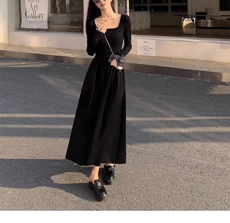 Women's black square collar knitted A-line dress with long sleeves on a hanger.
