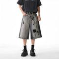 Grey water washed hole denim shorts with loose fit and cropped length on hanger