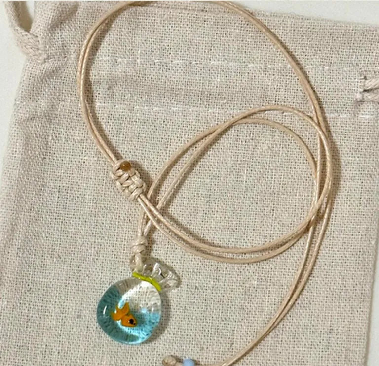 Women's necklace with a coloured glaze Small Fish Lucky Bag pendant on a cotton and linen clavicle chain.