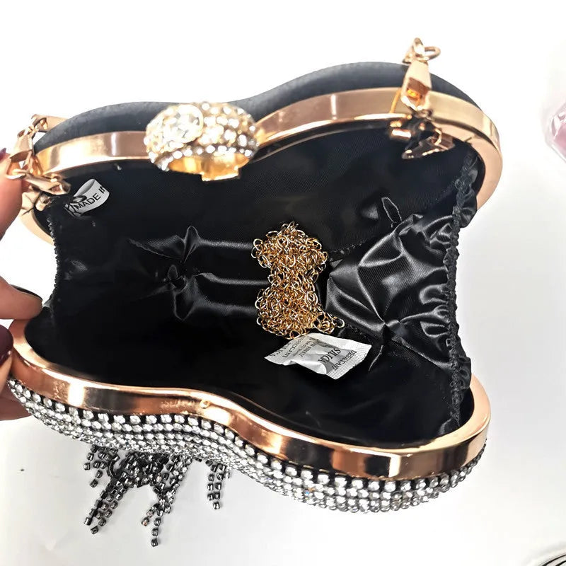 Women's heart-shaped metal dinner bag with tassel detail in black, gold, and silver options