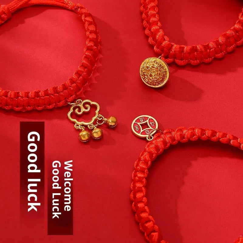 Adjustable hand-woven red rope pet collar with alloy lucky charm on wooden surface
