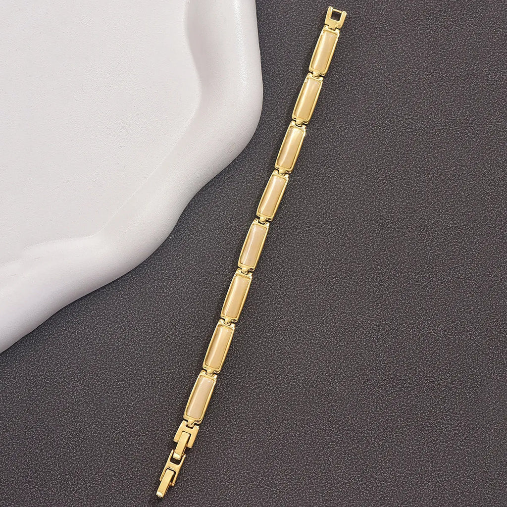 Women's geometric rose gold opal bracelet with quadrilateral shape and gemstone inlay on a plain background