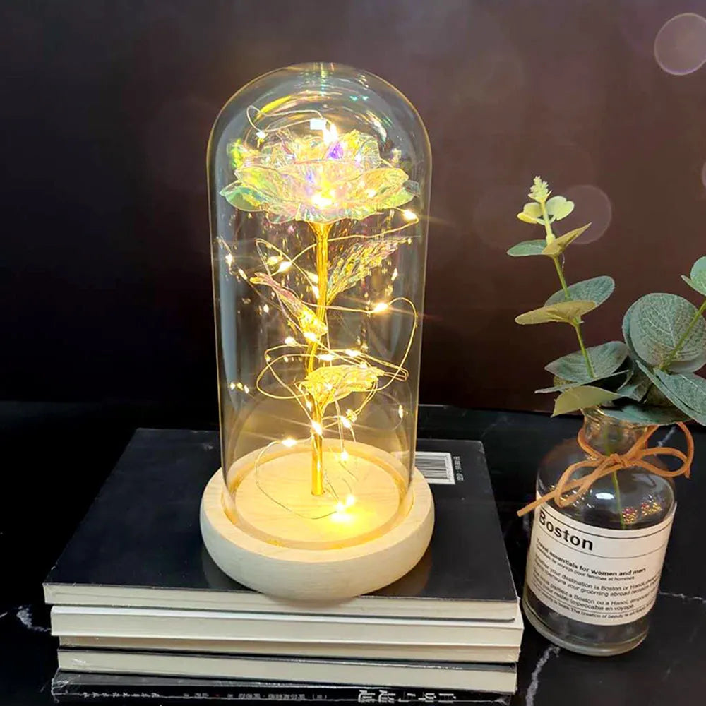 LED illuminated silk rose bouquet in a glass dome on a wooden base, with warm white lights.