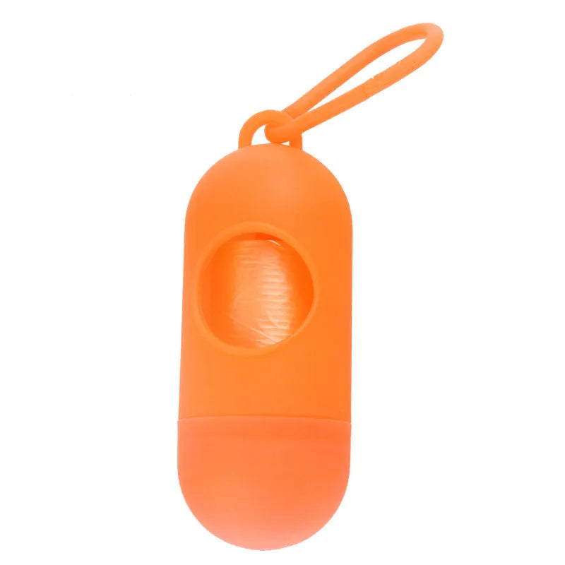 A compact black dog poop bag holder with a side hook and Velcro strap, shown next to a roll of waste bags.