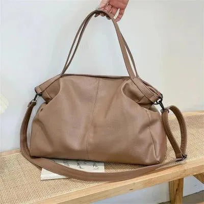 Large horizontal soft PU messenger bag in black with zip opening and long shoulder strap.