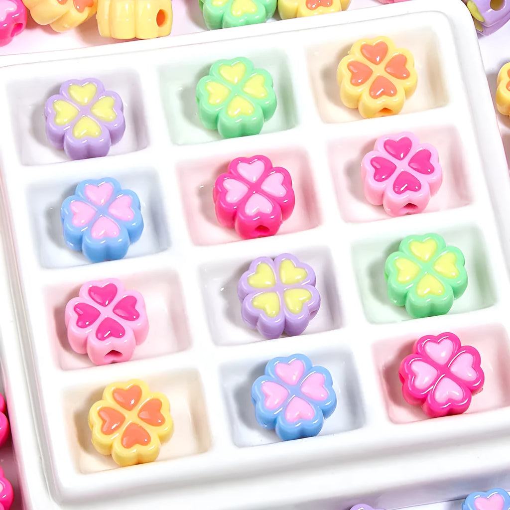 Assortment of frosted acrylic four-leaf clover shaped beads in rose red, pink, yellow, green, blue, and purple colours.