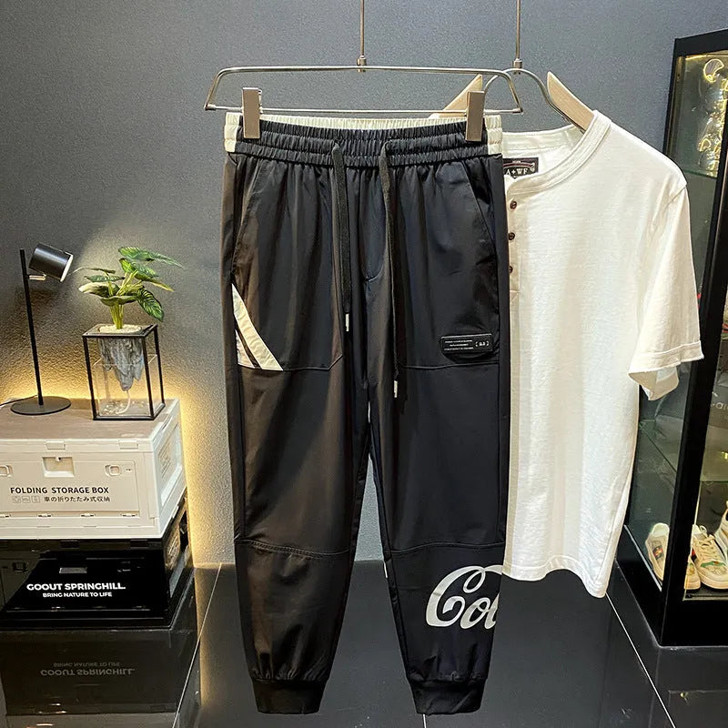 Men's black cropped casual trousers with an ankle band made from thin cotton fabric.
