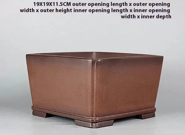 Brown handmade purple clay ceramic flower pot with antique style, shown on a surface.