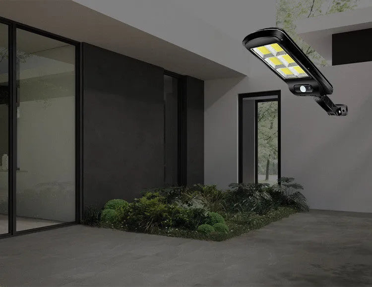 Black solar-powered outdoor security light with motion sensor for garden and driveway illumination