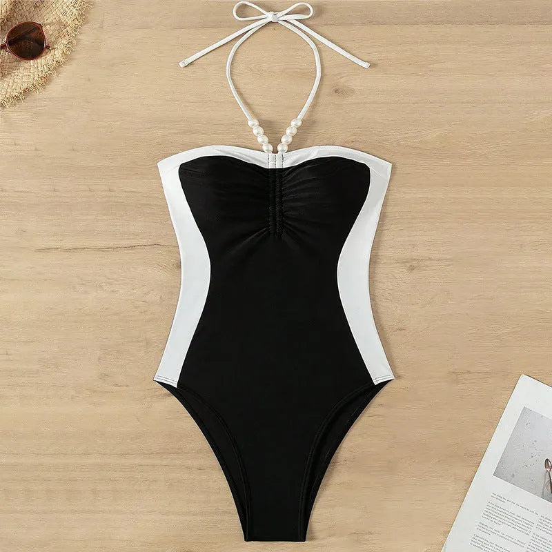 Black and white women's one-piece swimsuit with spaghetti straps and a slimming silhouette