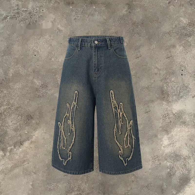 Men's black denim cropped shorts with flame embroidery patch design on leg