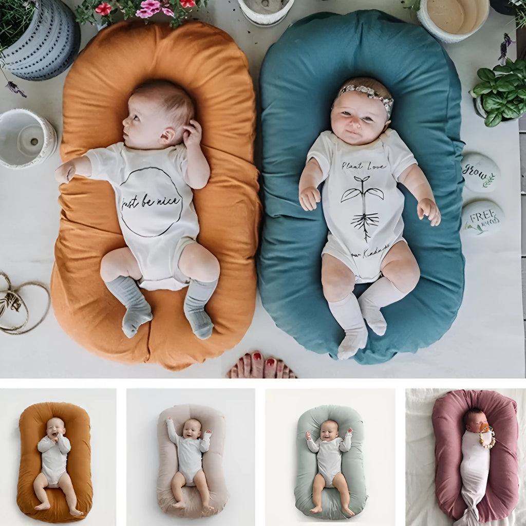 Beige portable baby nest crib for newborns measuring 75cm by 45cm on a neutral background.