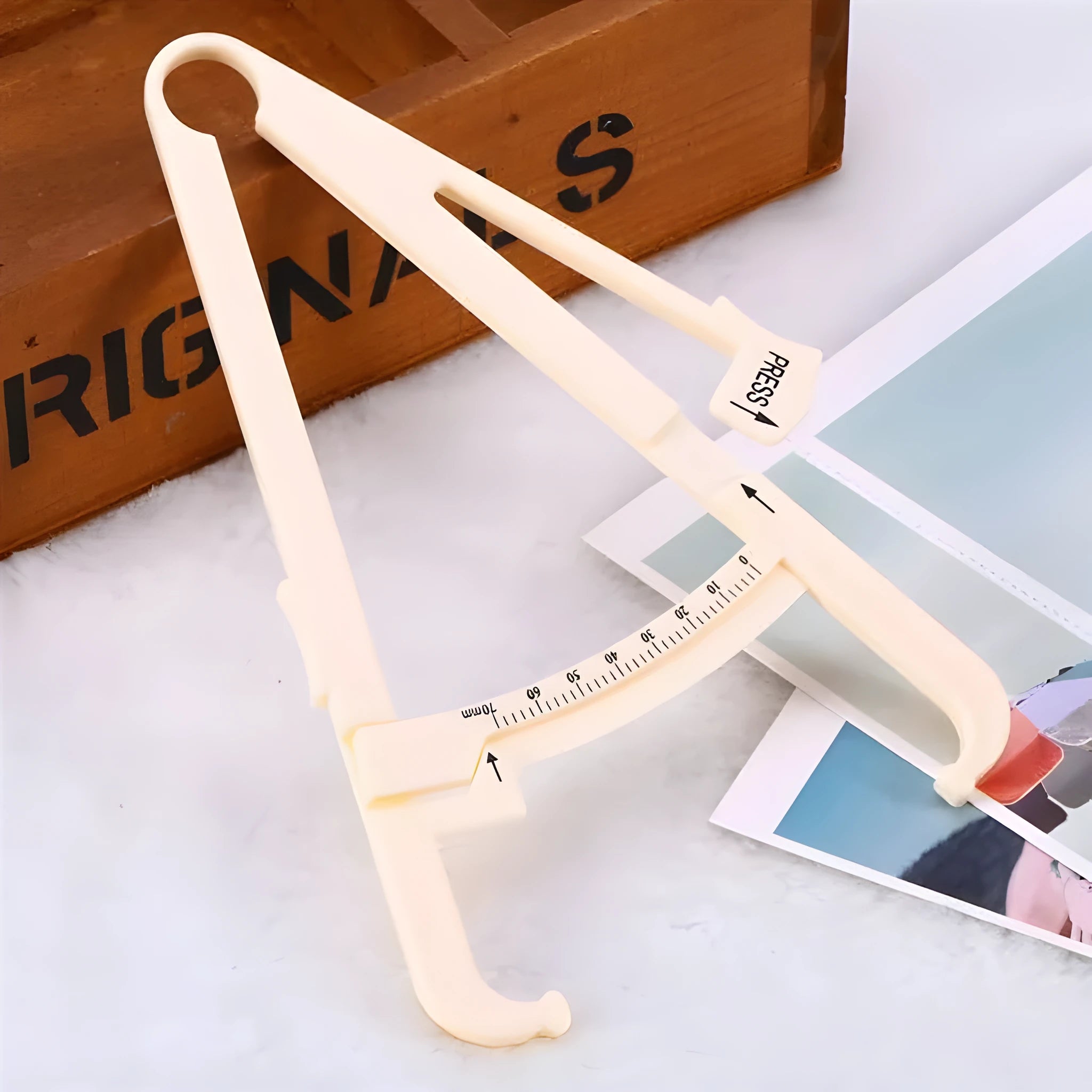 Clear acrylic body fat caliper with measurement scale showing 200mm range and 0.001mm accuracy.