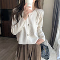 Women's long-sleeved acrylic cardigan sweater in milky white, shown with front open.