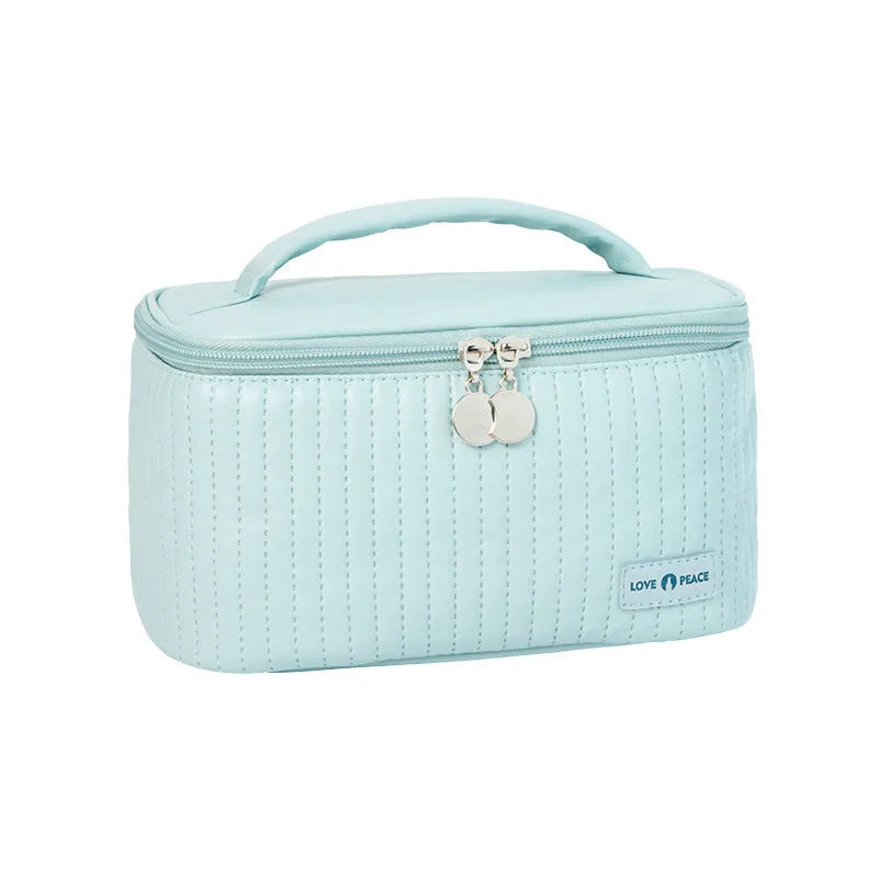 Open-top solid colour PU leather makeup bag in light blue on a white surface
