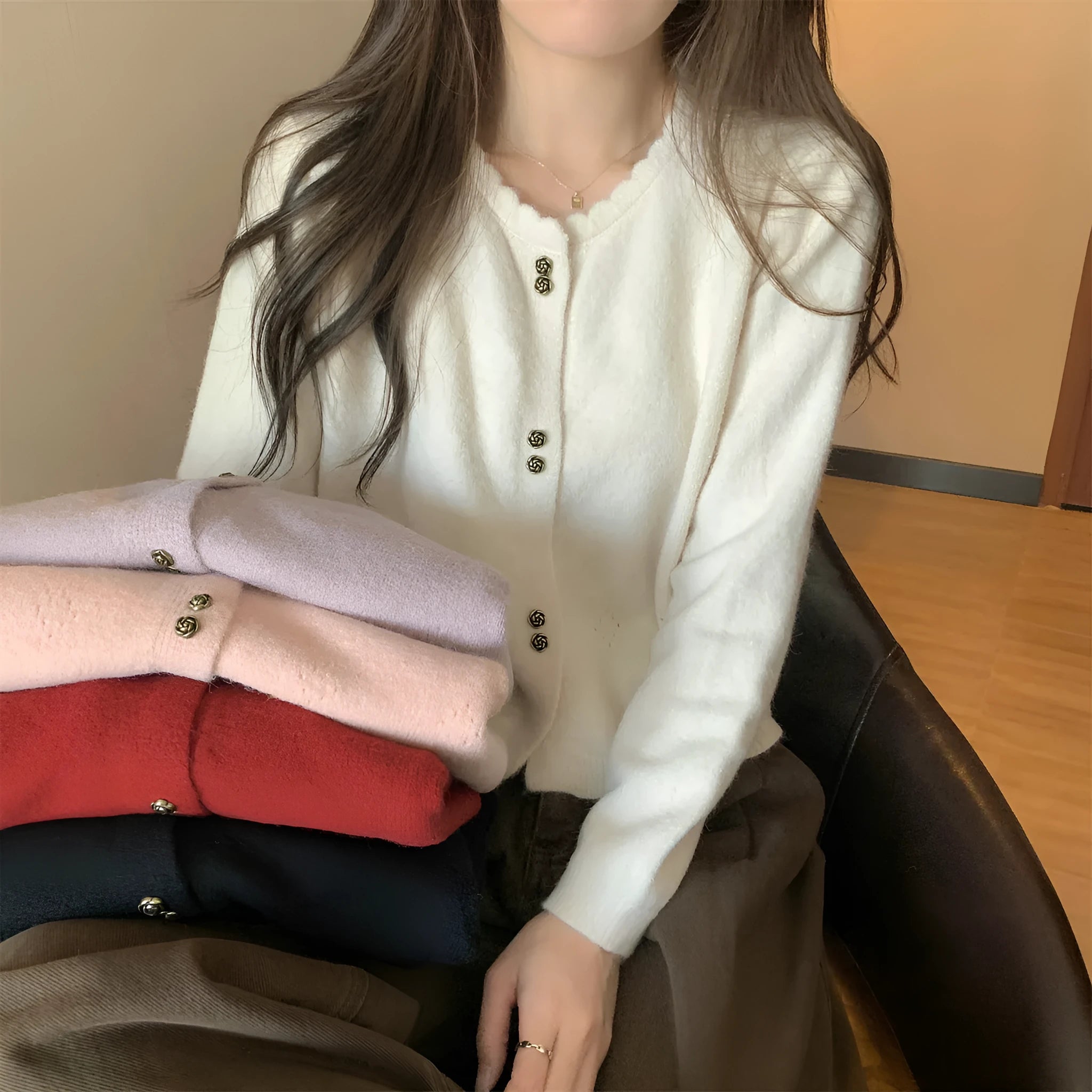 Women's long-sleeved acrylic cardigan sweater in milky white, shown with front open.