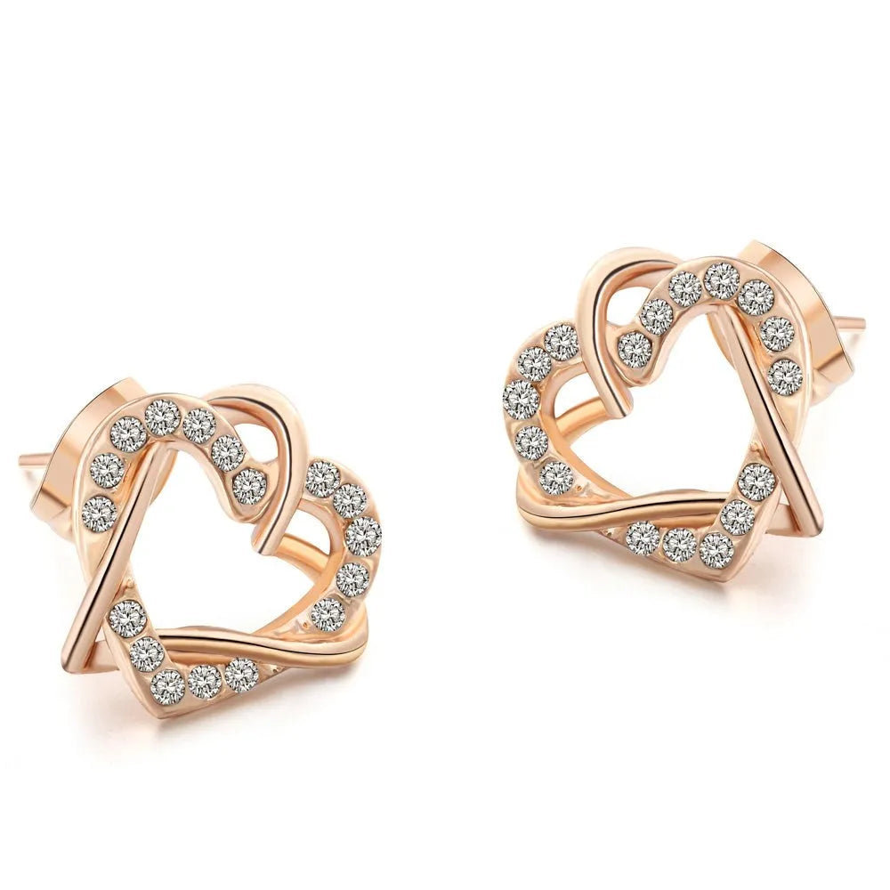 Gold colour alloy heart-shaped stud earrings on white background