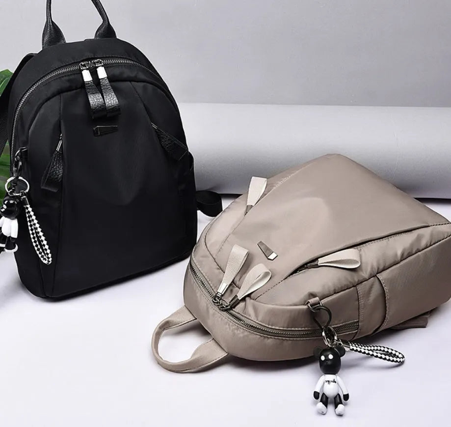 Medium-sized grey Oxford cloth rucksack with double straps, shown open to reveal internal phone and ID pockets.