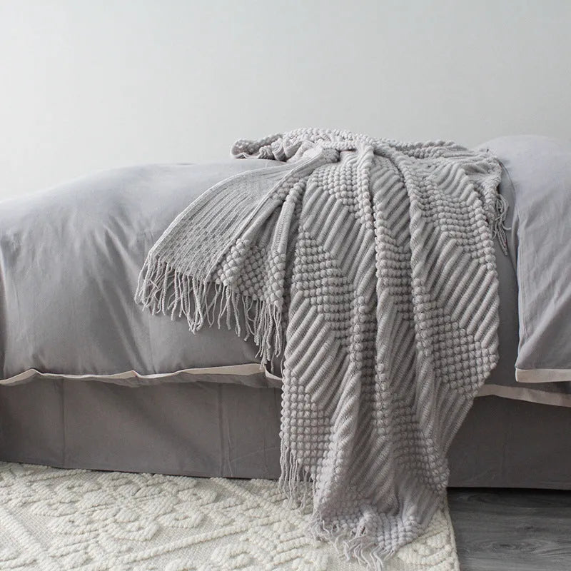 Small polyester blanket in dark grey, khaki or light grey colours measuring 127 by 170 centimetres