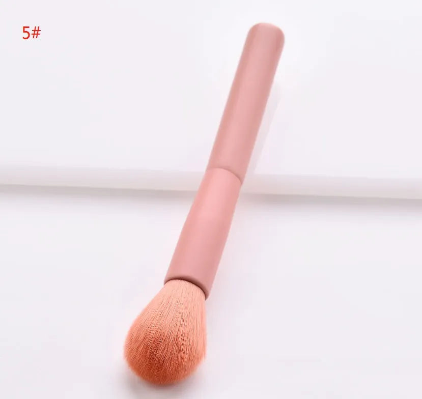Ten professional makeup brushes with wooden handles arranged by size for different cosmetic applications