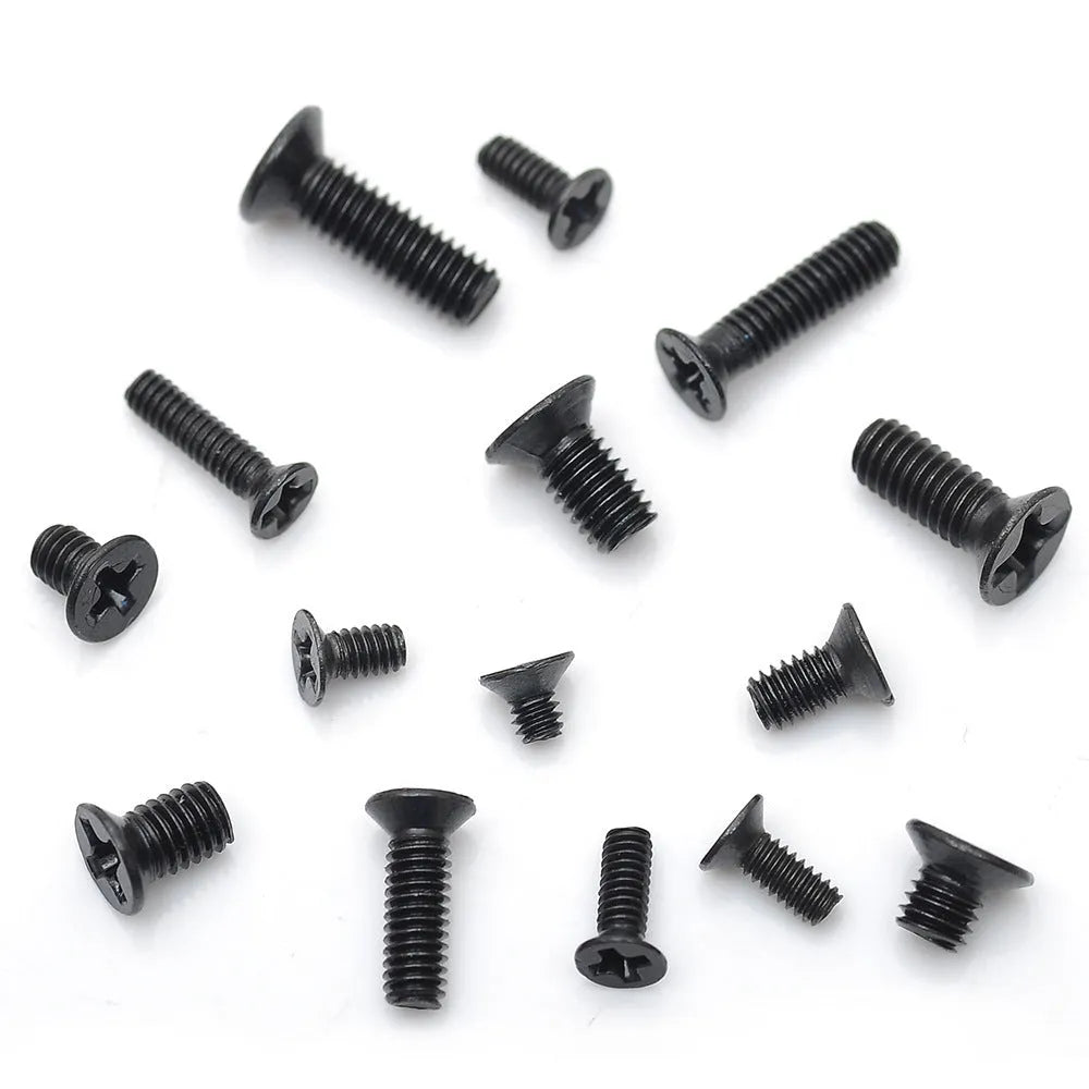 Black countersunk head machine screws for laptop repair in a box, showing cross-drive groove.