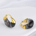 Copper geometry shape retro Maillard style earrings with electroplated finish in amber colour option on plain background