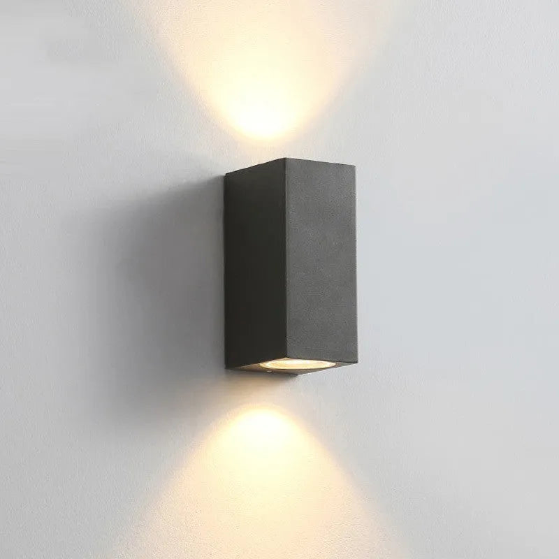 Modern black wall lamp with aluminium body, clear glass shade, and silicone rubber accents.