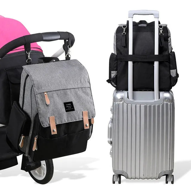 LAND Mommy large grey diaper backpack with multiple compartments and a changing mat laid out