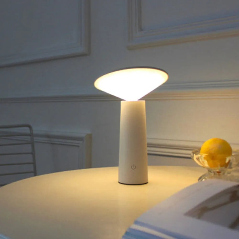 Black USB rechargeable LED desk lamp with touch sensor on a wooden desk, showing its adjustable lamp head.