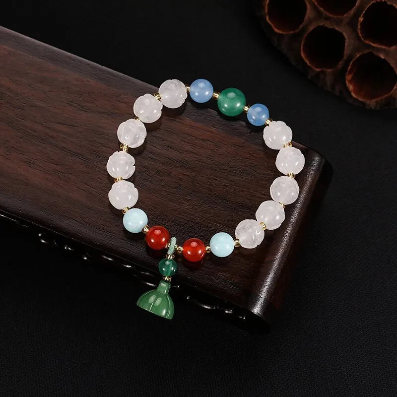 Carved Bodhi root bracelet with white jade, lotus, and pumpkin beads in various sizes.