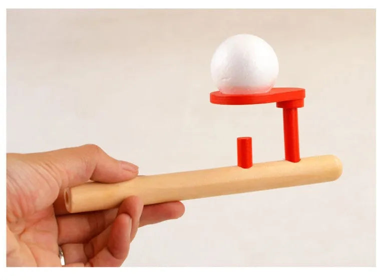 Wooden blowing balls magic suspension toy in red colour, 14 x 6 cm, on a white background