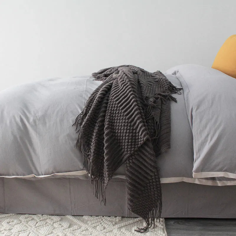 Small polyester blanket in dark grey, khaki or light grey colours measuring 127 by 170 centimetres