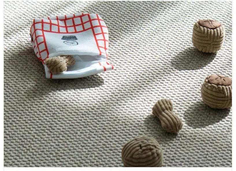 Hidden food toy set for dogs with two walnut toys, one peanut toy, and a rustling paper snack bag on a table