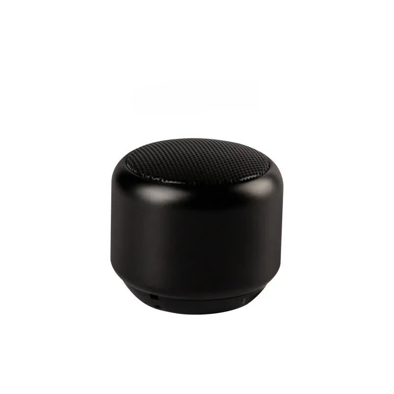Small portable Bluetooth speaker in black, blue, gold, or pink colour on a table.