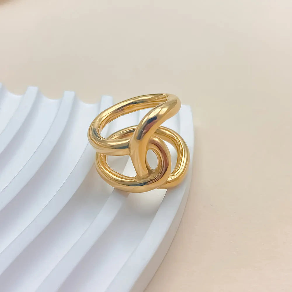 Adjustable geometric ring with knotted design in stainless steel showing U-shaped form and opening mechanism