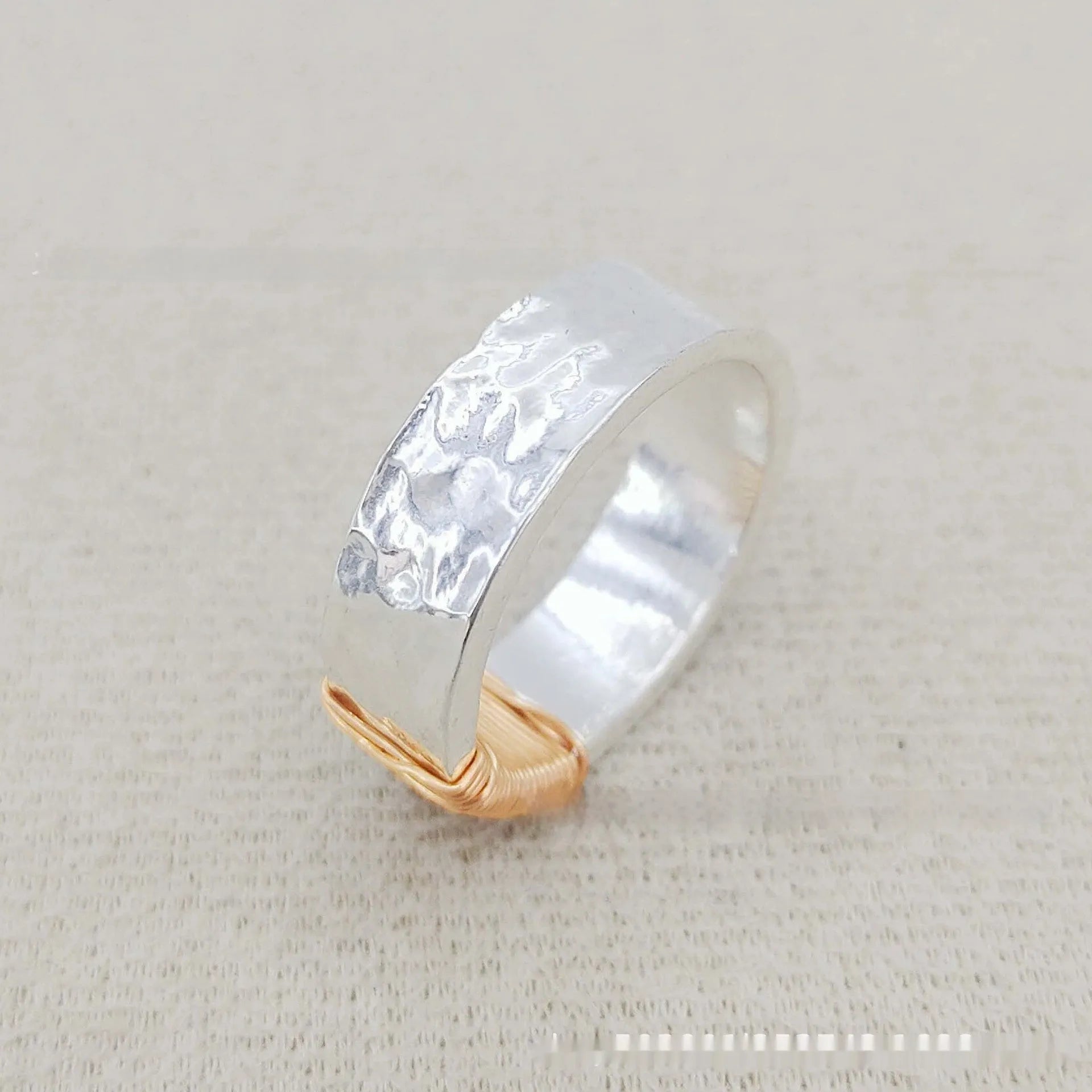 Silver golden geometric copper bracelet with an irregular coil and wide face ring design.