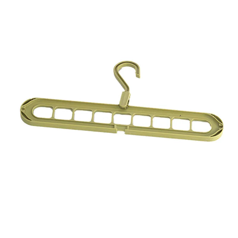 Green plastic folding clothes hanger with nine holes for organising trousers on a rack.