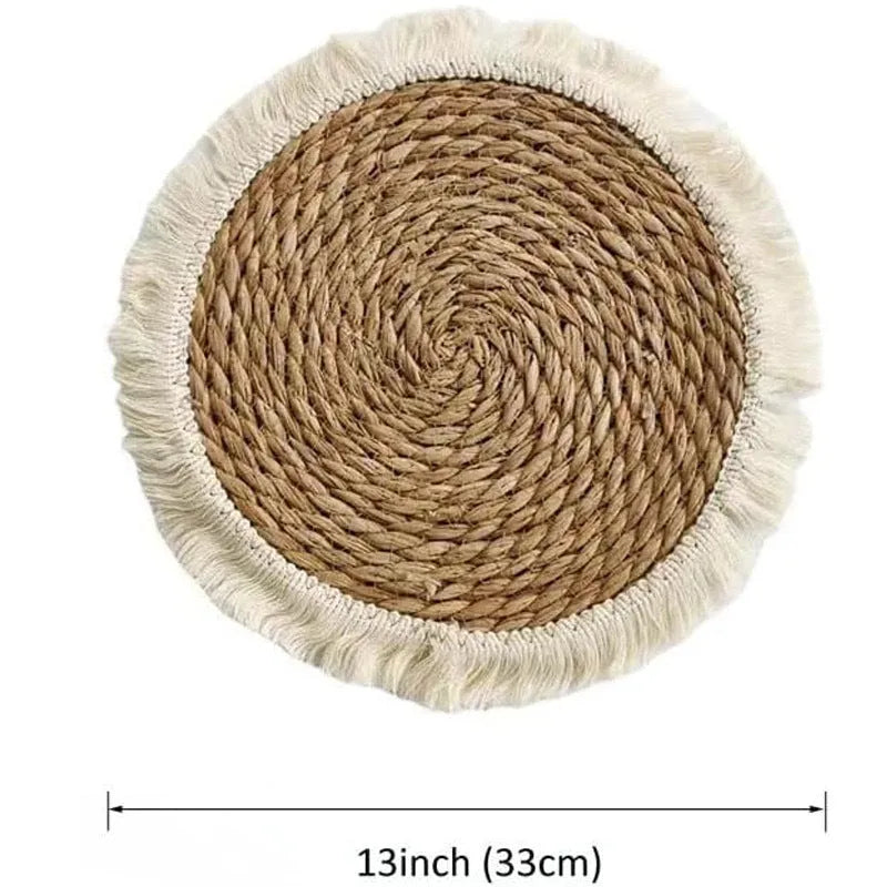 Round natural papyrus straw placemat with decorative tassels on a table