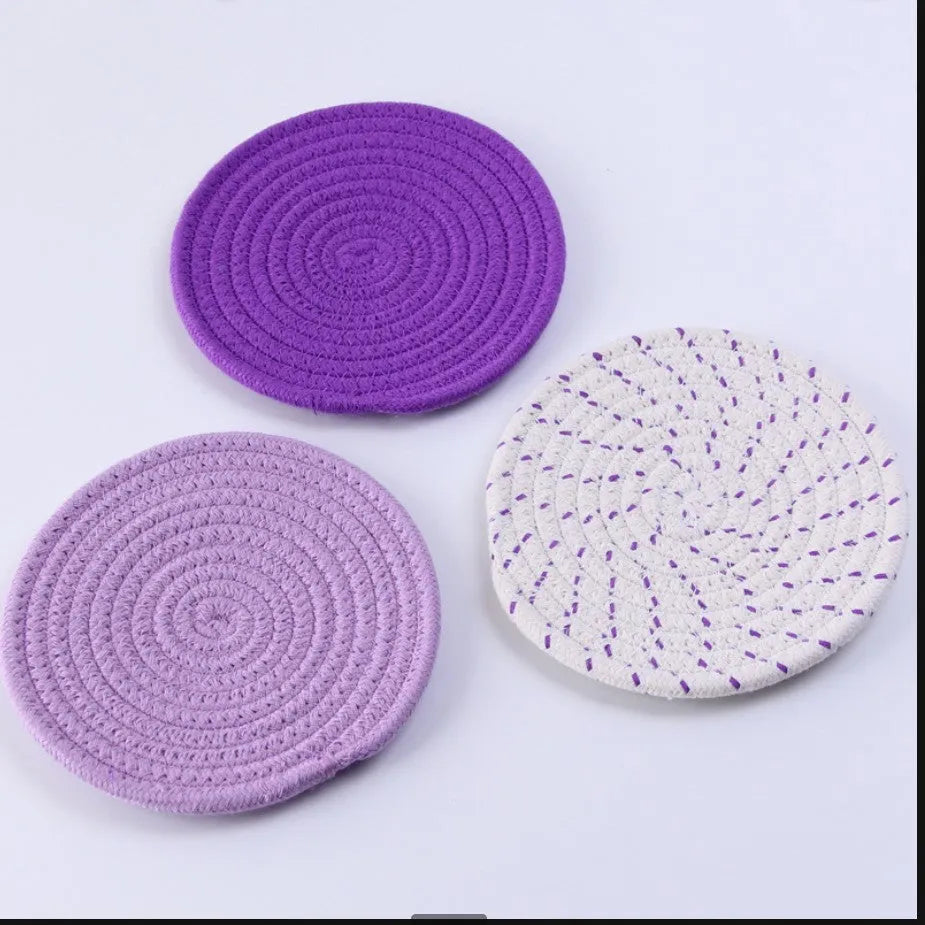 Set of three round grey cotton cord coasters, each 18 cm in diameter, on a wooden table.