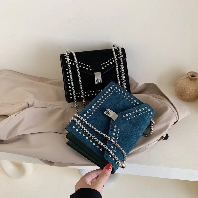 Small PU shoulder messenger bag for women with lock detail, chains, and rivet decoration on a soft flap.