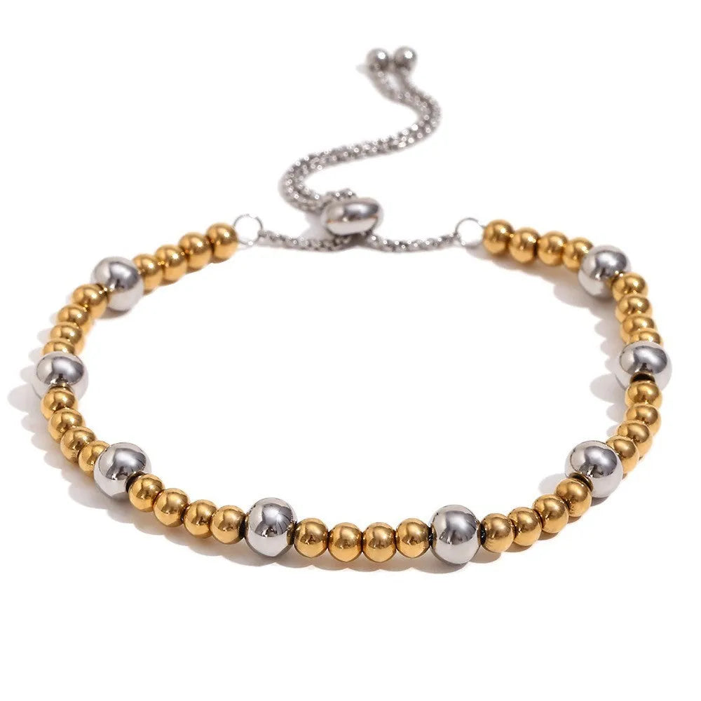 Gold geometric stainless steel earrings, bracelet, and necklace set on a white background.
