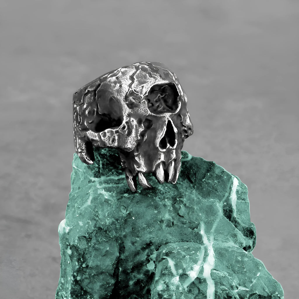 Alloy one-eyed skull ring in retro punk style on a black background.