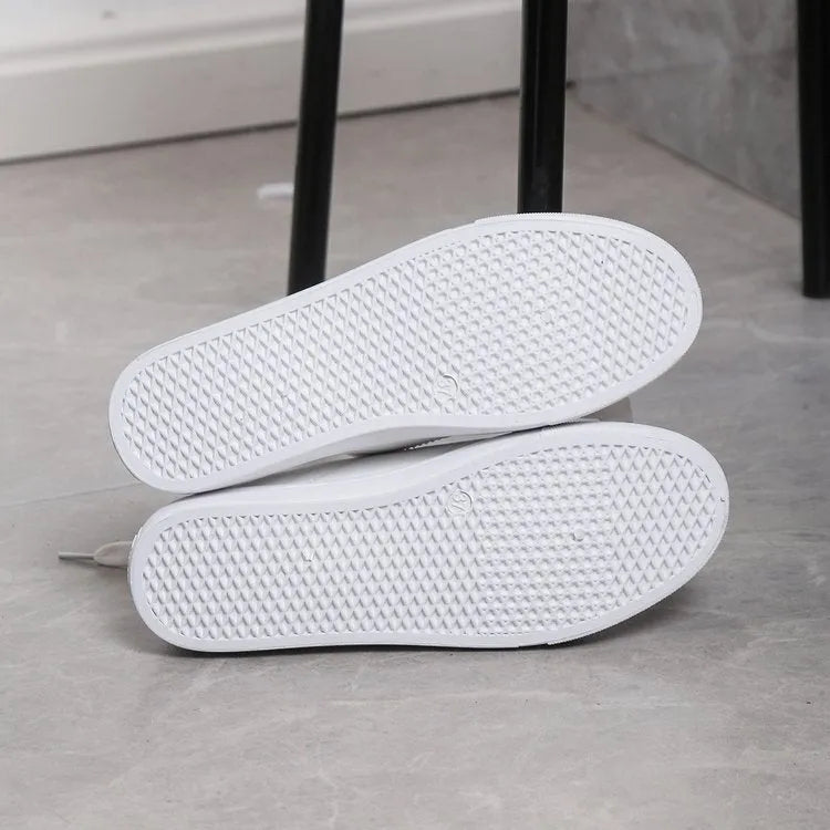 White round toe lace up casual shoes with platform heel on a flat surface