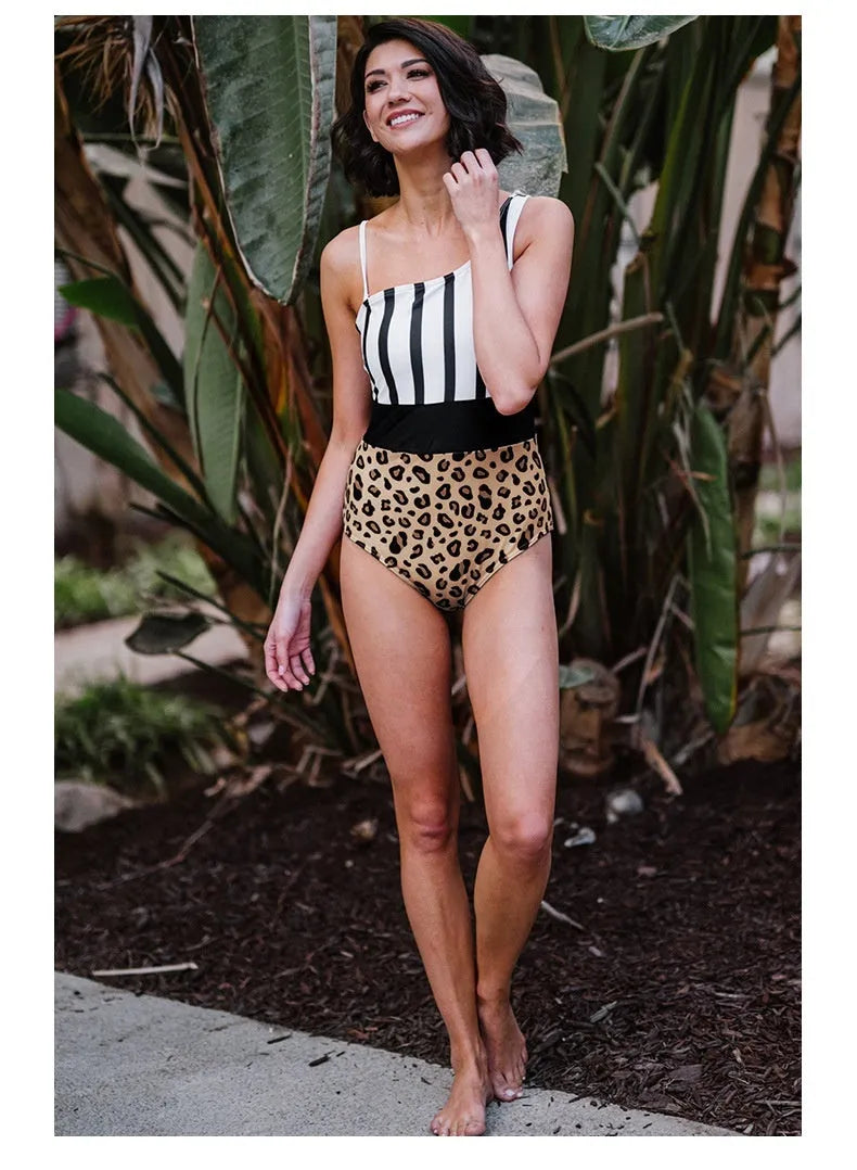 Women's leopard print one-piece swimsuit with asymmetric collar and high-waist briefs on a mannequin.