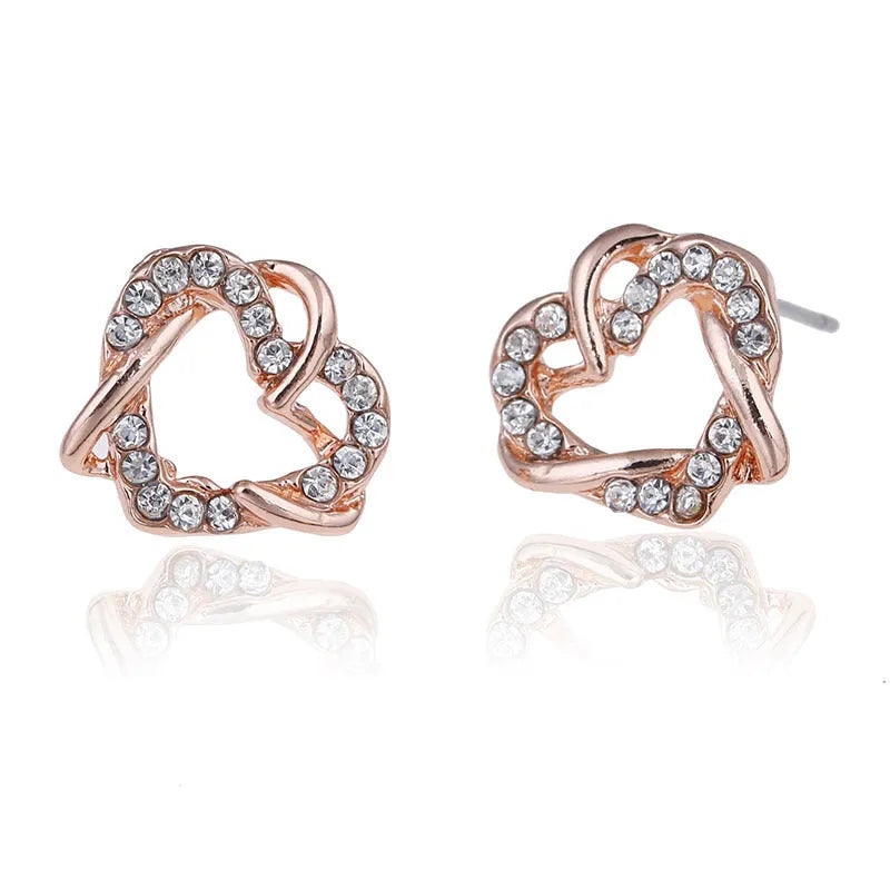 Gold colour alloy heart-shaped stud earrings on white background