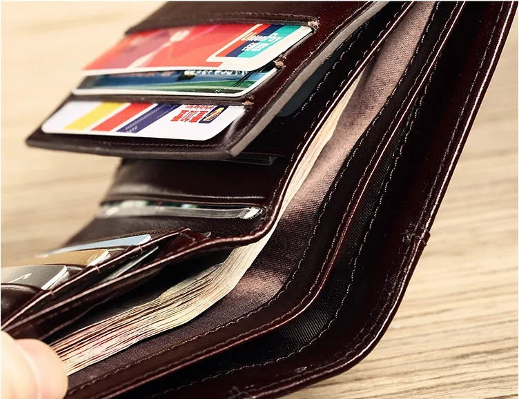 Men's compact leather wallet open showing card slots, change pouch, photo slot, and dark privacy compartment.