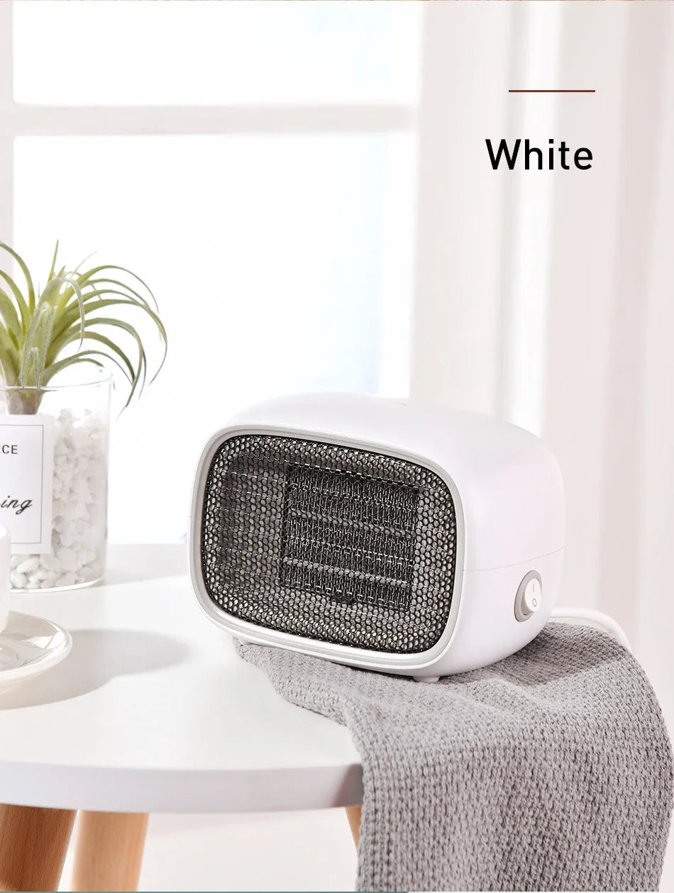 Green mini PTC ceramic fan heater showing compact size and metal mesh front grille.