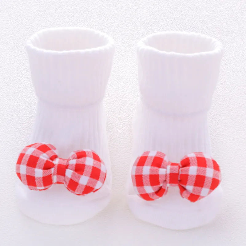 Cotton baby socks in multiple colours and prints including panda, lion, bows, and stars on a white background.