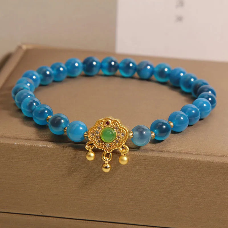 Blue sugar heart agate safety lock pendant on a crystal women's bracelet with alloy-set stones.