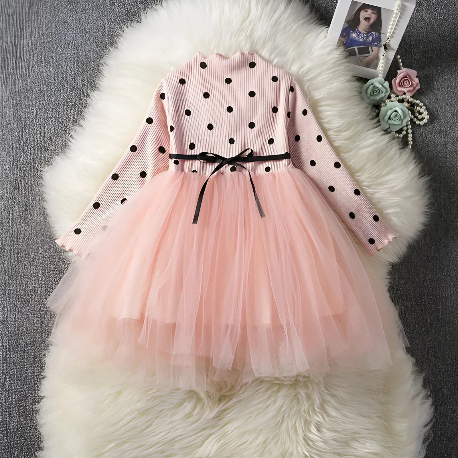 Baby girl wearing a long sleeve white lace tutu dress for a birthday or christening.
